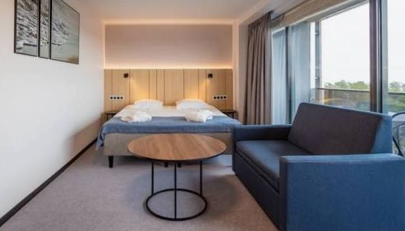 Premium Room with lounge chair, desk and warm accent lighting